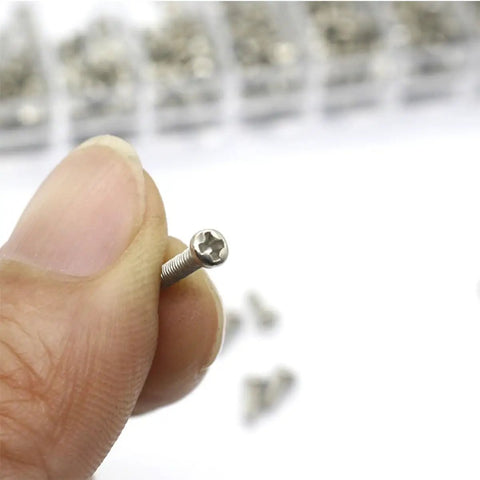 Hand holding silver screw from Miniature Screw Kit Set With Silver Tiny Screws For Eyeglasses, Sunglasses And Watches, Glasses Repair Tools