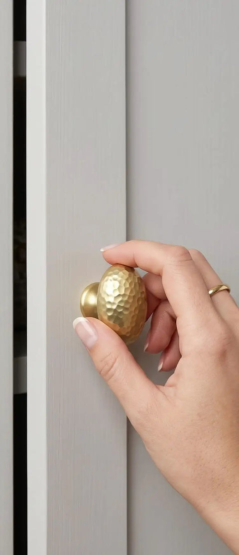 Top Shelf Champagne Bronze Cabinet Knobs With A Hammered Oval Dome and Soft Metallic Luster, 1 3/8 inch, installed on cabinet.