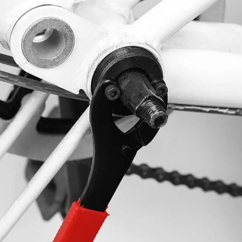 Bottom Bracket Tool Adjustable Pin Spanner And Lock Ring Wrench engaged on bike part, carbon steel, 16.3 cm, red handle.
