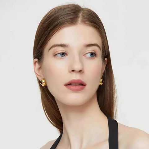 Half Ball Stud Earrings for Women, Gold Tone 20mm Round Ball Jewelry, Minimalist Yet Bold Everyday Earrings, Lightweight 3.2g, Gold Plated Stainless Steel, Lead Free, the Perfect Accessory That Goes With Any Fit. Model wearing gold half-ball stud earrings on white background