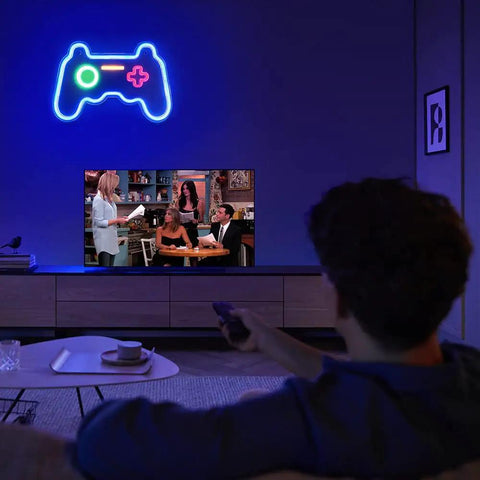 Neon Game Controller Sign LED Light for Gaming Room Decor 16x11 Inch Wall Light glowing above TV, in a dimly lit room.