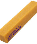 Yellow abrasive eraser stick, angled side view, 1-1/2 x 1-1/2 x 8 in, sanding block