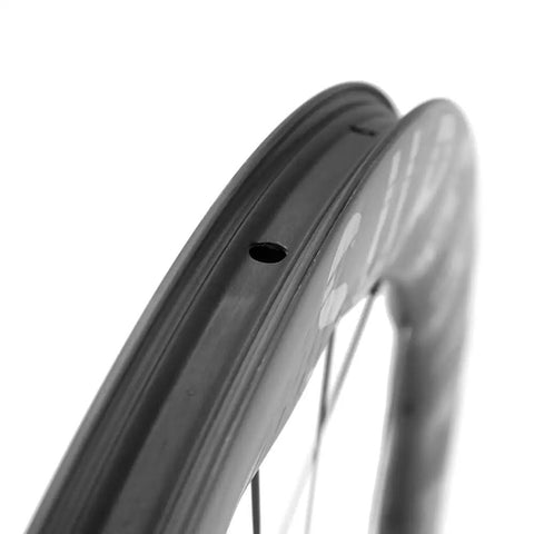 Close-up of Carbon Disc Wheelset S All D28 50 Tubeless With Carbon Spokes 700C rim detailing for ultralight and quick acceleration on road bikes.