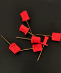 Close-up of 20Pack Archery Target Pins Heavy Duty Manganese Steel Nails with plastic heads, showing red pins on black background.