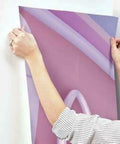 Person installing Minnie Fashionista Water Activated Peel And Stick Wall Mural Removable Disney Wall Decor on wall.