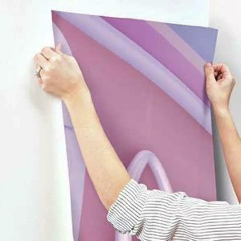 Person installing Minnie Fashionista Water Activated Peel And Stick Wall Mural Removable Disney Wall Decor on wall.