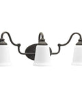 Three Light Bath Vanity Light From Wander Collection In Venetian Bronze Finish Dope Transitional Style Victorian Inspired Bathroom Lighting Damp Rated Bronze Dark Tone For Classic Modern Bathrooms with etched opal glass shades.