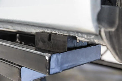 Close-up of 4Pcs Universal Jack Bracket Pads With Slot Design Pinch Weld Blocks For Car Chassis Protection, heavy-duty steel adapter under car.