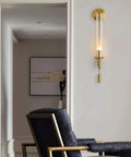 Modern Long Tube Wall Sconce In Brushed Gold Metal And Frosted Glass casting a chic warm glow in a stylish hallway.