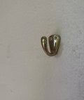 Small Solid Brass Wall Mounted Hanging Hooks Duo Pack Slick Dope Gold Finish showing a single hook on a white wall.