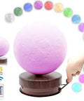 Magnetic Levitating Moon Lamp With Wireless Charging And 3D Printed Rotating LED Light, 16 Color Modes glowing pink on stand.