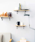 Heavy Duty Folding Triangle Brackets For Shelves holding wooden shelves with books, jars, and mugs in a modern living room.