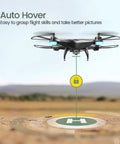 FPV RC Drone With 1080P HD Camera hovering in a field, showcasing auto hover feature for stable photography and flight control.