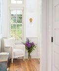 Gold Modern Bath Wall Sconce With Opal Glass Globe Vanity Lights Set Of 2 in a cozy white reading nook with armchair and flowers
