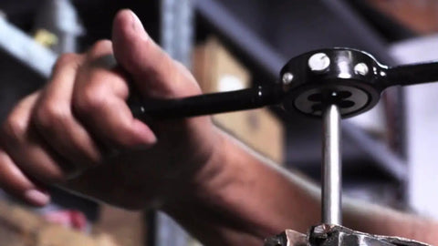 Person using One Eighth Inch NPS Tap And One Inch OD Round Die Kit HSS National Pipe Straight Tap And Die Set on metal pipe