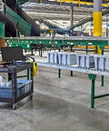 Two Shelf Foam Utility Cart With Lipped Shelves And Ergonomic Handle Black 500 Lb Capacity Durable Rolling Cart in a warehouse.