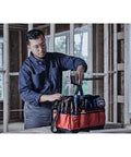 IRWIN Quick-Lift construction jack in a red tool bag with branding; worker in a workshop.