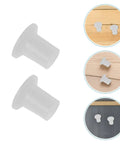 Thinking Process: white plastic skating bearing spacers for wheels, small cylindrical inserts shown on wood and dark surfaces