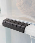 Close-up of a secure latch on a see through 53 quart stackable plastic storage bin with lid for home organization, BPA free, made in USA