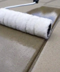 Application of Top Shelf Penetrating Concrete Sealer For Driveways And Patio Slabs using a paint roller on a patio surface.