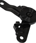 Hood hinge assembly, black metal with coiled torsion spring, close-up view.