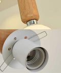 Top Shelf Three Head Disc Pendant Ceiling Light With Milky Frosted Glass Lampshades And Heavy Duty Wrought Iron Frame close-up of wooden and metal fixture.