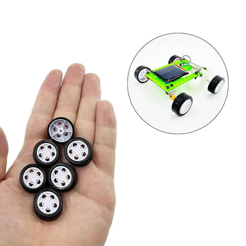 Hand holding toy wheels from Ten Piece Small Toy Car Wheel Set With 20mm Rubber Tires And 5 Shaft Axles For RC Cars Trucks Robots DIY