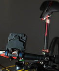 Badass Bicycle Laser Calibrator And Saddle Positioner Bike Tool With Integrated Charging Port mounted on bike handlebar.