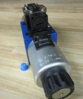 Close-up of Hydraulic Solenoid Directional Control Valve 4WE10D40/OFCG24N9DK24L with 24VDC coil and 4-pin connector on a wood surface.