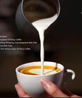 Pouring dense milk foam into coffee cup highlighting creaminess and texture for barista-quality coffee.
