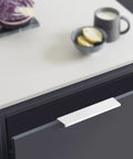 White aluminum edge pull installed on kitchen cabinet drawer, part of Six Piece Edge Pulls For Cabinets Finger Pull Cabinet Hardware Aluminum Hidden Handles 80mm White Finish For Furniture Drawers And Cabinets Dope For DIY Projects And Home Upgrades.