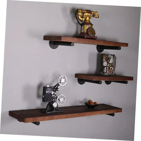 Rock Solid Heavy Duty Wall Mounted Shelf Brackets Four Pack Black Iron Pipe Style holding rustic wooden shelves with decor items.