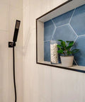 Matte Black Square Wall Elbow For Handheld Shower Durable Solid Brass Fitting With One Half Inch IPS Female Inlet And One Half Inch NPSM Outlet Leak Proof Modern Square Design That Fits Standard Hoses And Hand Showers installed in bathroom with blue tile accent.