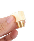 Hand holding a brass NPT hex bushing adapter, showing 3/8 inch male to 1/2 inch female pipe fitting with hex head for durable connections.