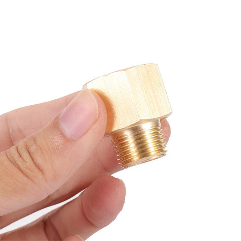 Hand holding a brass NPT hex bushing adapter, showing 3/8 inch male to 1/2 inch female pipe fitting with hex head for durable connections.