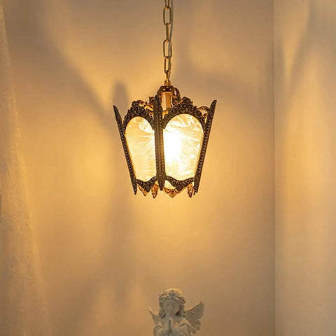 Cool Copper Pendant Light With Ice Crack Glass Lantern illuminating a corner with warm glow, angel statue below.