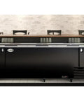 Heavy Duty Commercial Bottle Cooler, 95 Inch, 29.7 Cu Ft, Black Freestanding Drink Dispenser With Built In Opener, 3 Glass Doors, 5 Spacious Shelves, Digital Temp Control, Sick Chill Setup For Bars And Gameday Parties inside a bar setting.