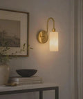 Modern Alabaster Wall Sconce - Natural Marble Wall Lamp with Luxury Brass Finish illuminating a stylish hallway.