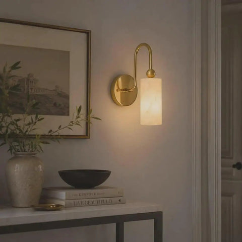 Modern Alabaster Wall Sconce - Natural Marble Wall Lamp with Luxury Brass Finish illuminating a stylish hallway.