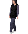 Model wearing unisex cobbler apron with deep front pockets, classic fit, black, 27.5 inches long, perfect for kitchen workshop and craft projects.