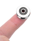 10 Pack 4X18X8MM V Groove Ball Bearings, miniature guide roller on a finger, showcasing steel sealed design for smooth movement.
