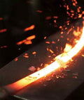 Crafting Oftner Hand Forged Austrian Scythe Blade for Harvesting Grain and Grass, glowing steel being shaped on an anvil.