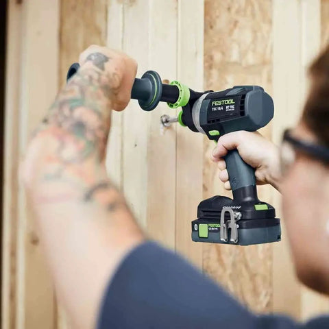 Person using Heavy Duty Brushless Cordless Drill And Driver With Unbreakable Gears And 18 Volt Battery on wooden wall.