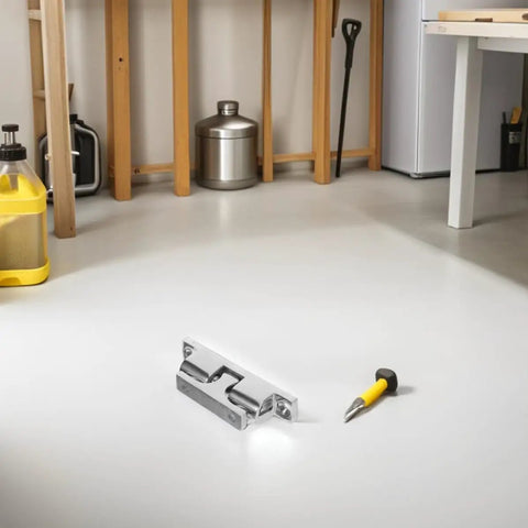 Sleek stainless steel door catch on white floor with screwdriver, perfect for yacht cabin doors to upgrade your boat.