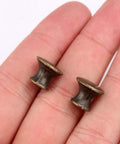 Close-up of two 10 Pcs Vintage Bronze Drawer Pull Handles Zinc Alloy Mini Metal Knobs held in hand for size reference.