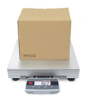 Heavy Duty Shipping Scale With A Rock Solid 18 X 18 Platform, 250 Lb Capacity And 0.05 Lb Precision with a package on top.