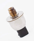 Master cylinder brake fluid pressure sensor close-up view; brass threaded fitting and silver metal body, black connector