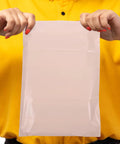 Person holding Khaki PE Mailers With Strong Glue And Easy Seal Waterproof Packaging Bags For Clothes And Cosmetics 100 Pack.