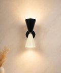 Mid-Century Two-Tone Cone Wall Sconce Light - Black & White Dual Funnel Wall Mounted Lamp with Gold Accent Ring - Up and Down Wall Lighting Fixture for Living Room & Bedroom on a beige wall.