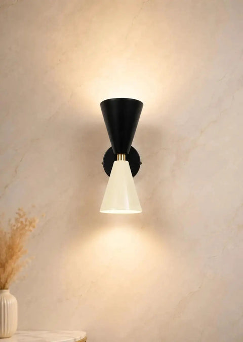 Mid-Century Two-Tone Cone Wall Sconce Light - Black & White Dual Funnel Wall Mounted Lamp with Gold Accent Ring - Up and Down Wall Lighting Fixture for Living Room & Bedroom on a beige wall.